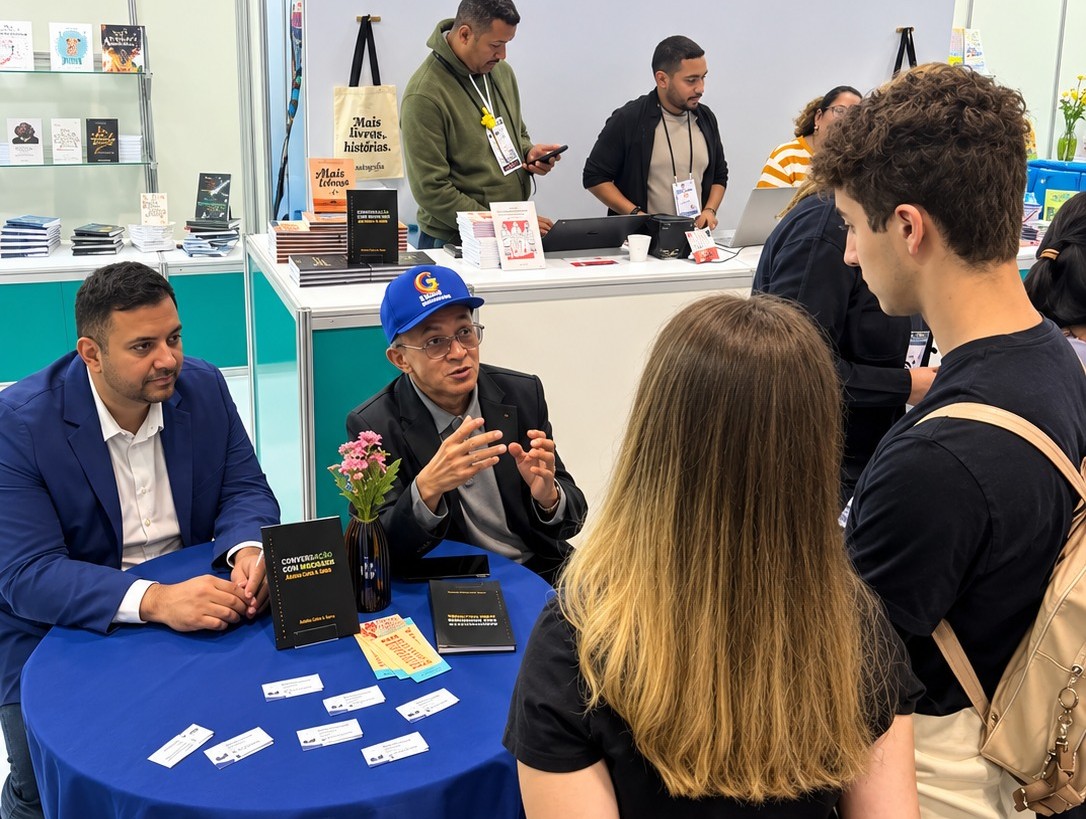 Professor Bibiano Costa de boné azul durante autógrafos na Bienal.