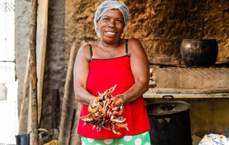 Mulher com caranguejos no litoral sul da Bahia